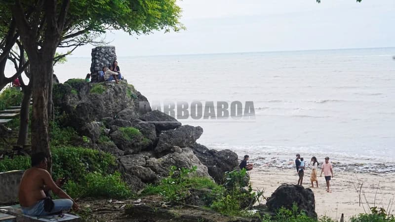 Sebuah keluarga tampak bermain dengan menanam badan di pasir.