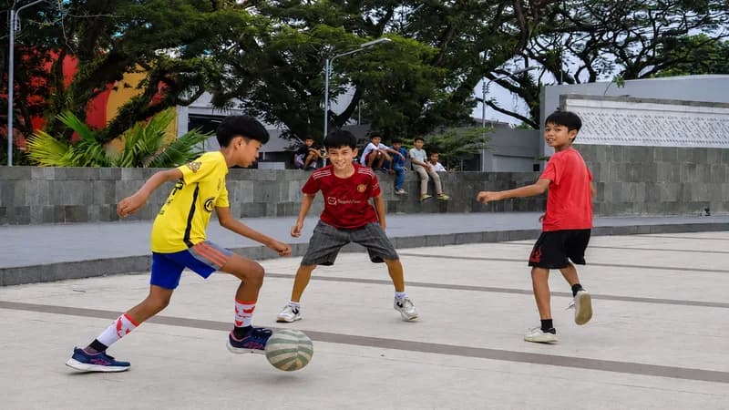 Anak-anak bermain bola di depan Gedung Stadion Teladan, Medan. (Foto: (Altamis/PARBOABOA).