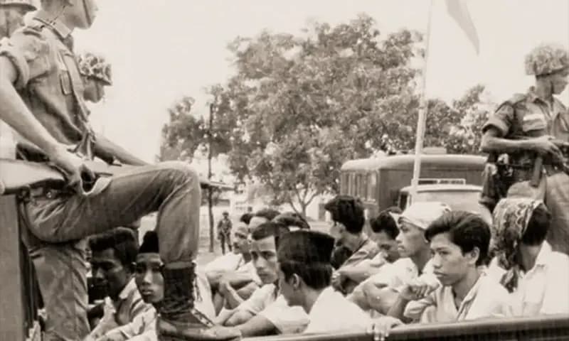 Salah satu potret tragedi Oktober 1965 di mana anggota Partai Komunis Indonesia (PKI) tengah dijaga tentara saat dibawa ke penjara di Jakarta (Foto: Dok. National Geographic)