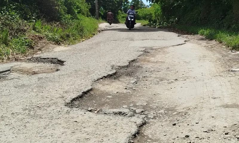 Kondisi jalan rusak di ruas jalan susur pantai Tigaras tepatnya di Dusun III Saragi Ras, Kecamatan Dolok Pardamean. (Foto: PARBOABOA/Pranoto)
