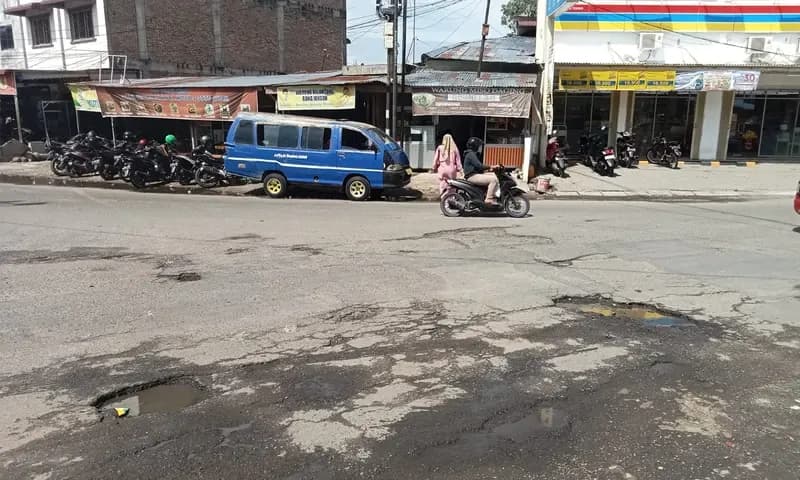 Masyarakat dan pengguna Jalan mengeluhkan lubang-lubang yang ada di Jalan Ir. H. Juanda, tepatnya di Simpang Dolok, Kota Tebing Tinggi, Sumatra Utara. (Foto: PARBOABOA/Ansori)