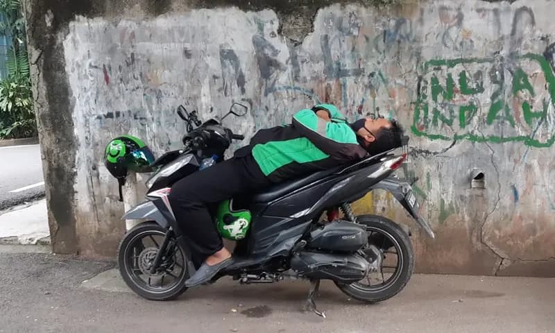 Musim hujan dan cuaca yang tidak menentu di Kota Medan, Sumatra Utara berdampak pada menurunya orderan pengemudi ojek online. (Foto: PARBOABOA/Bina Karos)
