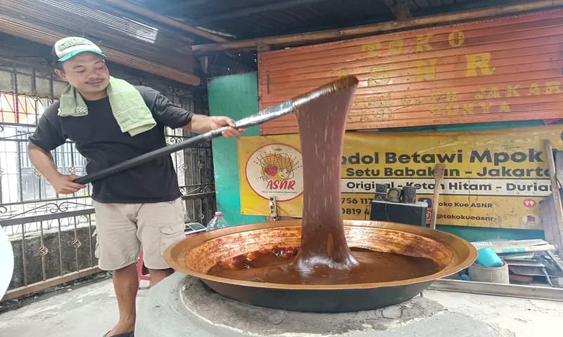 Peri, tengah mengaduk adonan kental dodol Betawi. (Foto: PARBOABOA/Dea Pitriyani)