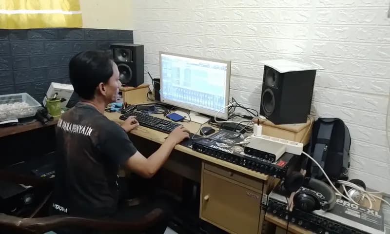 Eko (43), drumer Band KakiLangit sekaligus pendiri Dâ€™Gilazt Record sedang mengolah rekaman di studio miliknya pada Kamis (4/1/2024). (Foto: PARBOABOA/Roy Syahputra)