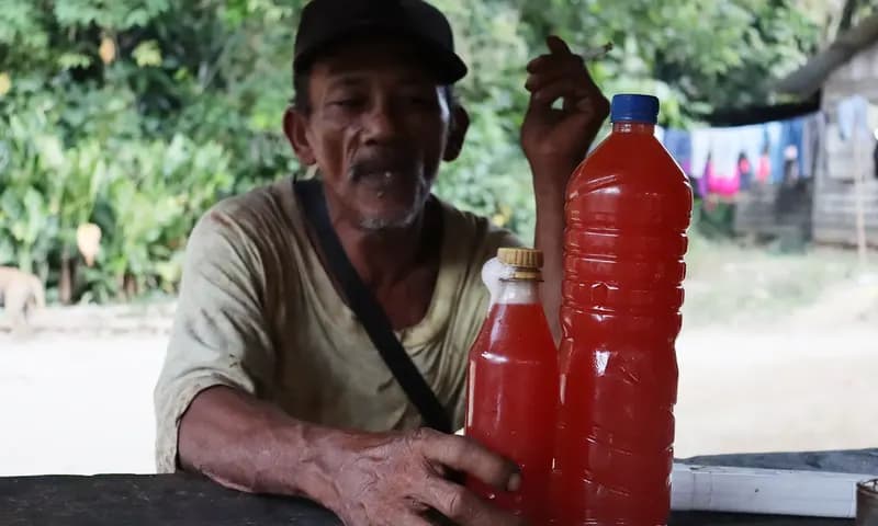 Jasiak Sumbayak dan tuak merahnya. (Foto: PARBOABOA/Calvin Siboro)