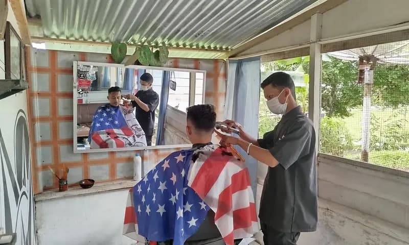 Ditengah tren mendaftar ASN di Simalungun, Nurul Kurniawan memilih menekuni profesi tukang cukur. (Foto: PARBOABOA/Pranoto)