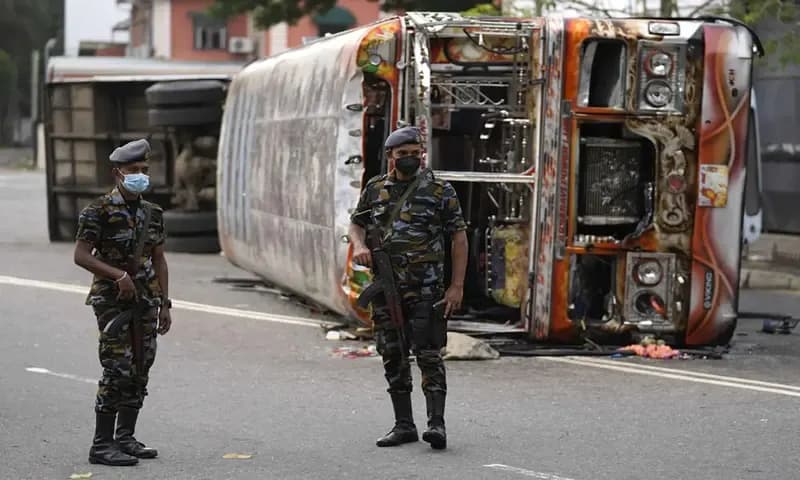 Pasukan keamanan Sri Lanka di Kolombo, berjaga dekat sebuah bus yang terbakar usai kerusuhan pada Senin. AP