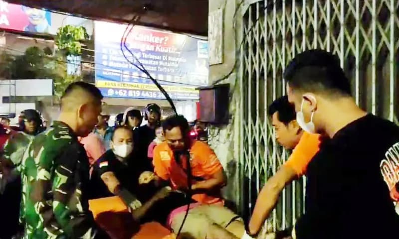 Jenazah JS (14), pedagang asongan yang diduga tewas akibat aliran listrik dari kabel sebuah papan reklame di Jalan MT. Haryono, Kecamatan Medan Kota, dievakuasi tim inafis Polrestabes Medan. (Foto: PARBOABOA/Ilham Pradilla)