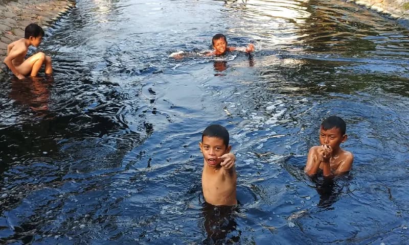 Suasana riang anak-anak berenang di sungai Cilemahabang, Desa Waluya, Cikarang Utara, Kabupaten Bekasi. (Foto: PARBOABOA/Muazam)