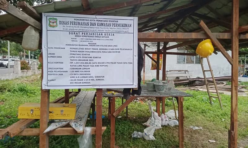 Plang proyek rehabilitasi taman makam pahlawan (TMP) Nagur di Jalan Sangnaualuh Damanik, Siantar Timur, Kota Pematang Siantar, yang dikerjakan oleh kontraktor CV. Raya Indonesia dengan nilai kontrak RP1,057 milliar. (Foto: PARBOABOA/Putra Purba)
